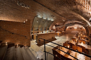 A restaurant with brick walls, wooden tables, and a bar area. - PREMIUM Wellness & Wine Hotel (Znojmo)