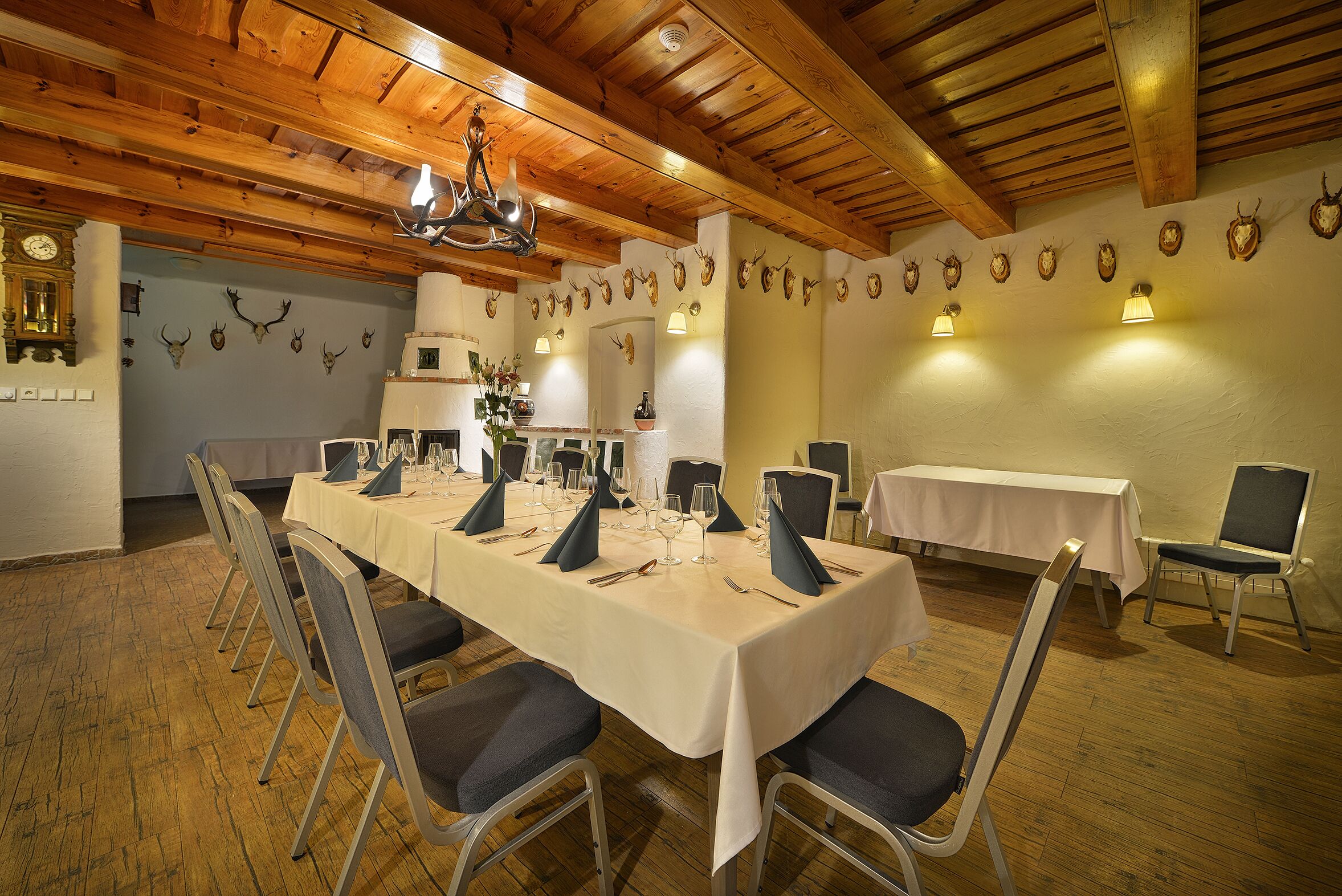 Un espace repas avec une longue table dressée pour le repas, entourée de chaises.