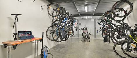 A bike storage area with multiple bicycles and a table with tools.
