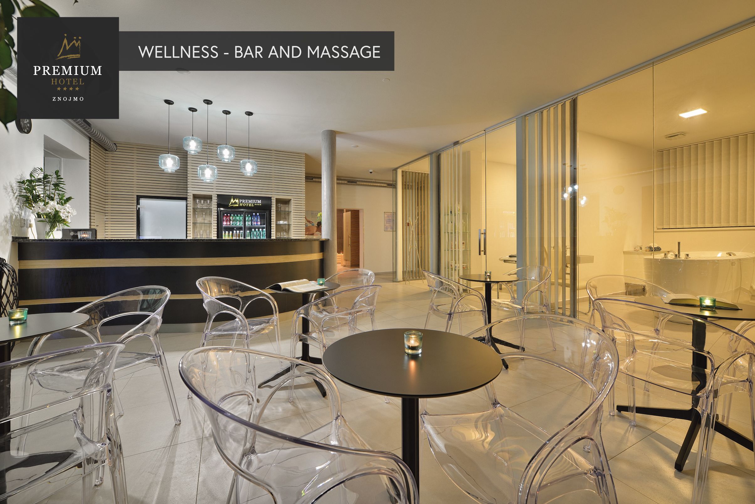 A modern wellness bar and massage area with clear chairs and tables, a reception desk, and a minibar.