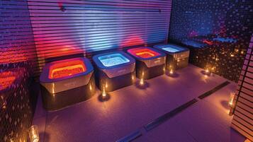 A spa area with four hot tubs labeled 'Cappuccino' under purple lighting.