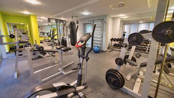 A gym with various exercise equipment, including treadmills, weight machines, and free weights.