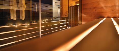 Un interior moderno con un largo banco, superficies reflectantes e iluminación ambiental.