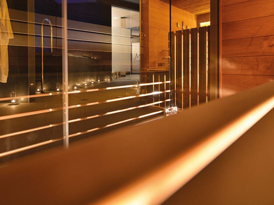 A modern interior with a long bench, reflective surfaces, and ambient lighting.