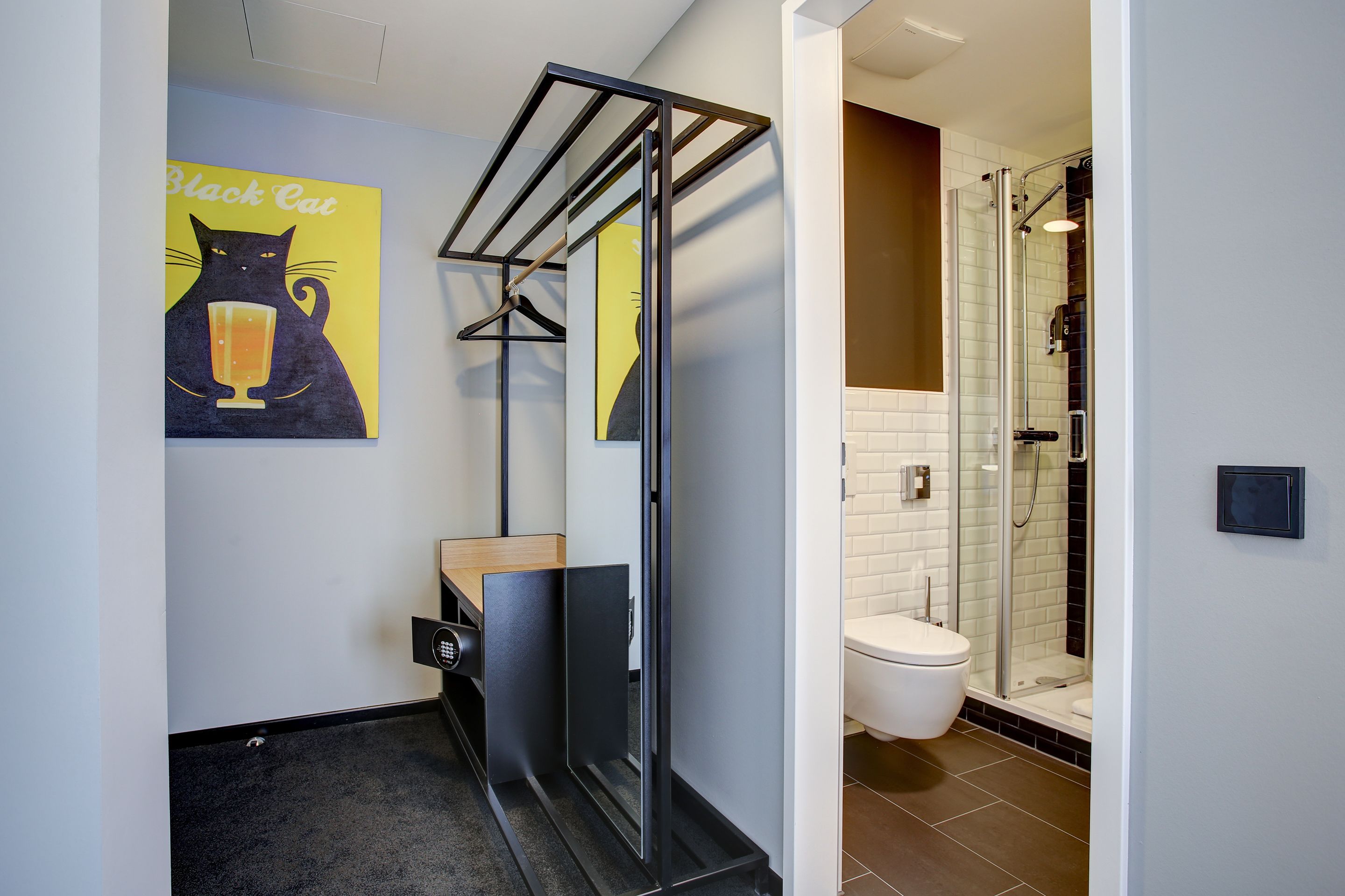A modern bathroom with a shower, toilet, and a towel rack.