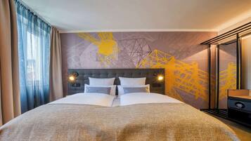 Quarto de hotel com cama grande, cabeceira com iluminação embutida, mesa de cabeceira e parede com padrão geométrico.