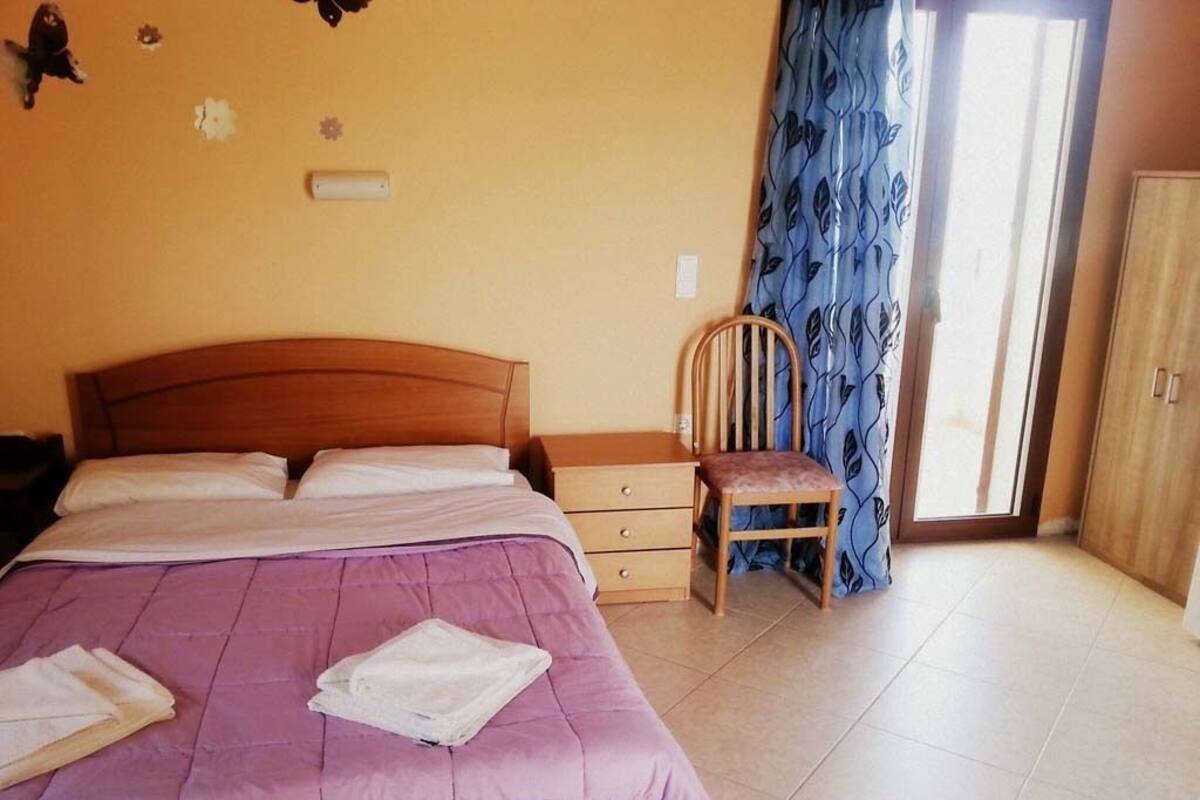 Une chambre à coucher comprenant un lit, une chaise, une commode et une armoire.