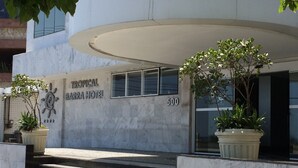 A modern building with a sign reading "Tropical Barra Hotel" and the number 500. There are steps leading up to the entrance, and potted plants are placed at the base of the steps. - Tropical Barra Hotel (Rio de Janeiro)