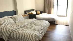 A bedroom with two beds, a nightstand, and a window with curtains. - Welcome Hostel (Hualien City)