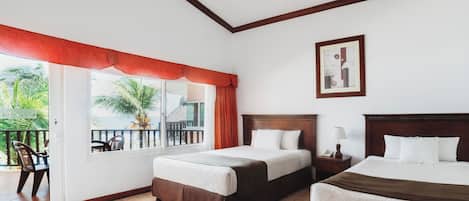 A hotel room with two beds, a balcony with chairs, and a ceiling fan.