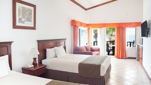 Habitación de hotel con una cama grande, una mesita de noche con lámpara, un televisor montado en la pared y vistas al exterior a través de la ventana.