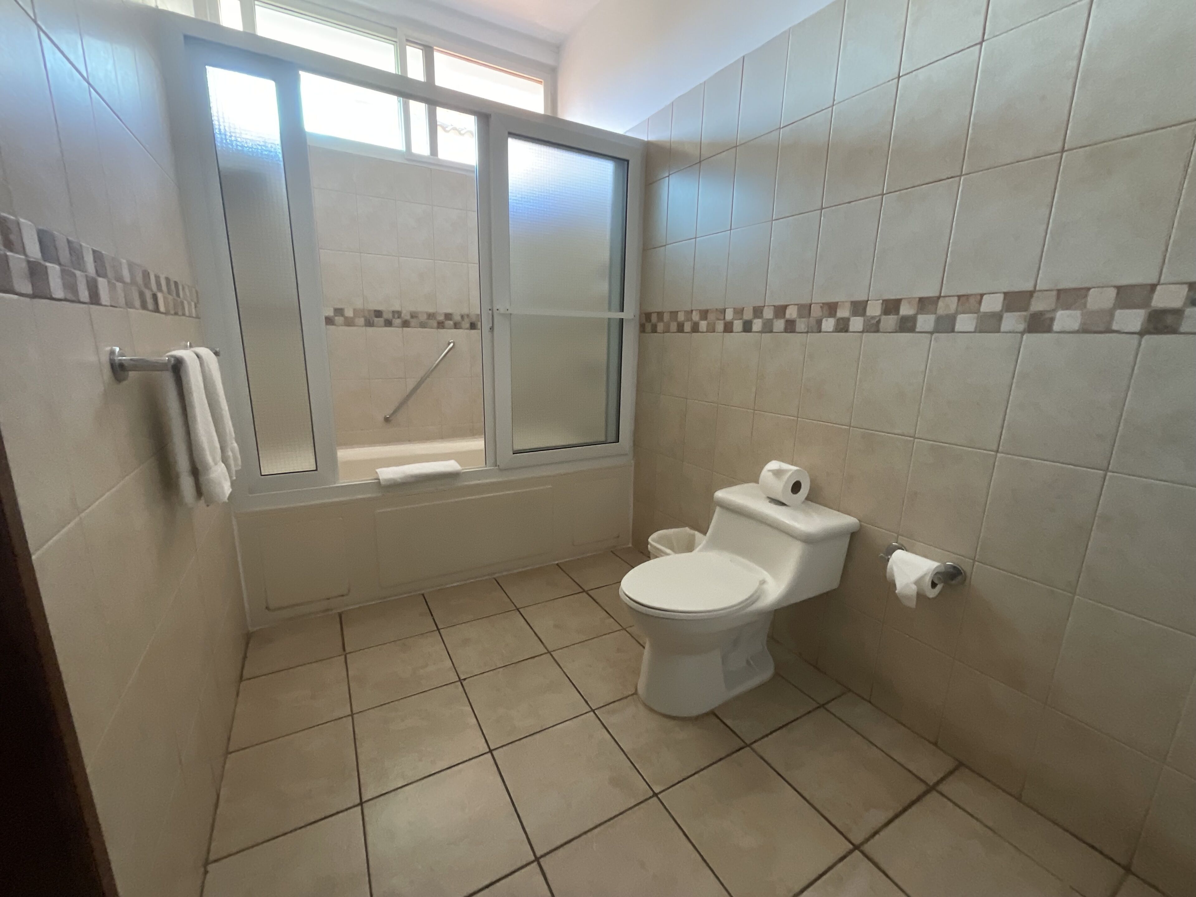 A bathroom with a toilet, a bathtub, and a shower.