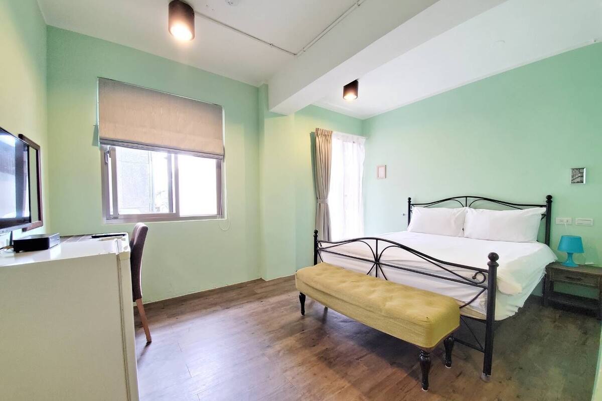 A room with a bed, a desk, and a window.