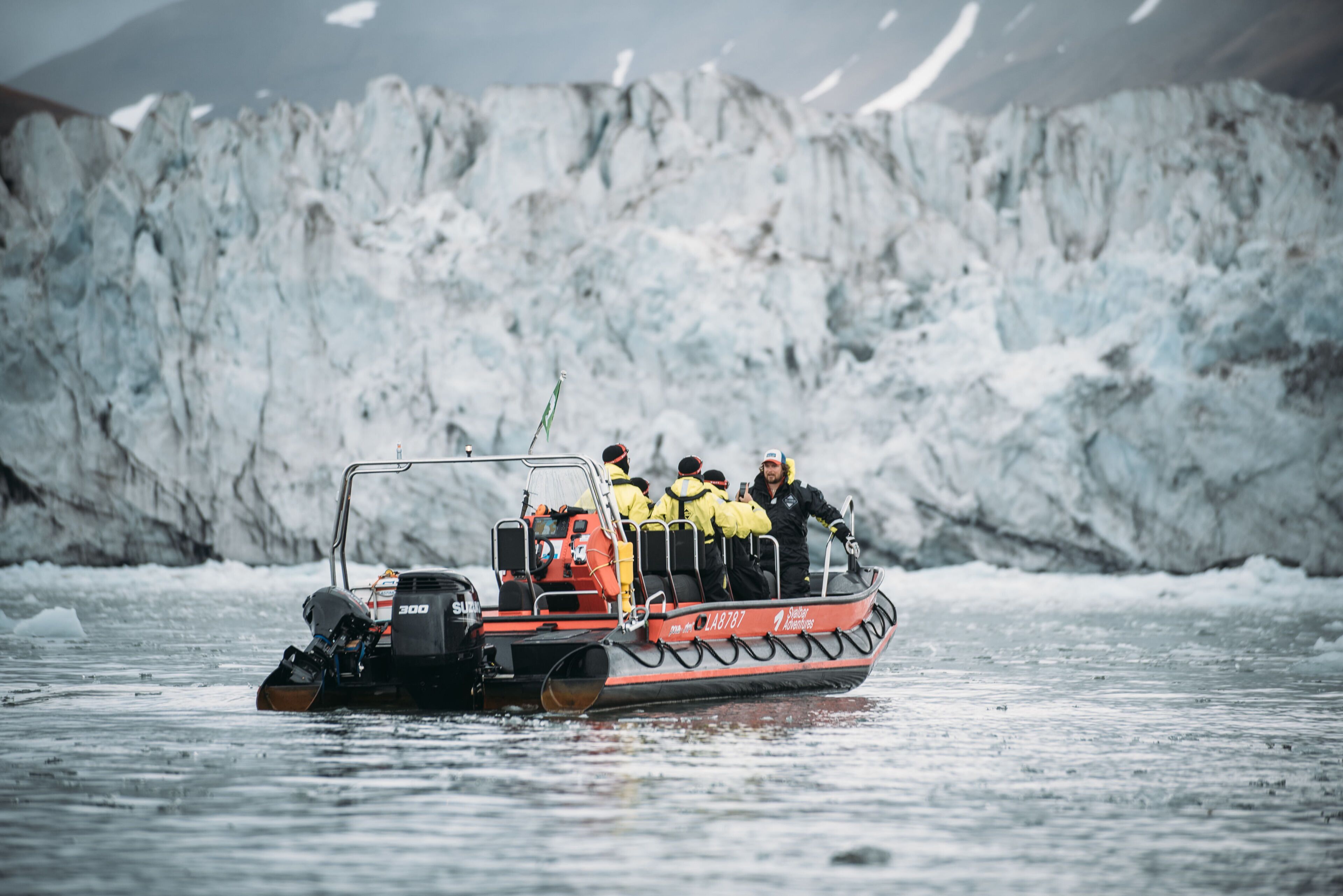A small boat with passengers on a glacier.