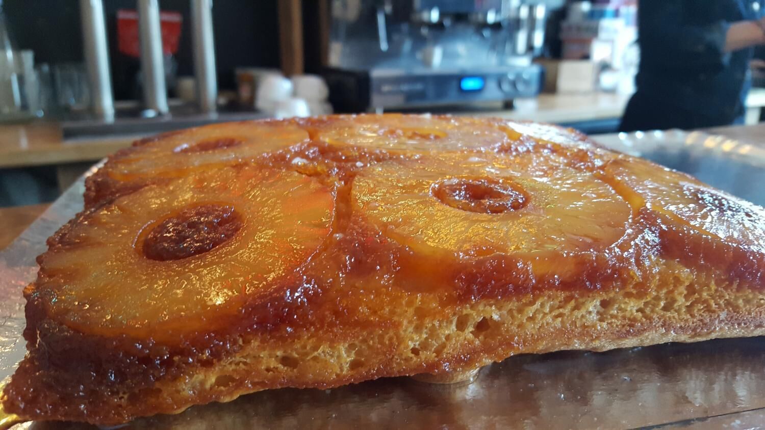 Une grande tarte aux fruits, ronde et recouverte d’un glaçage, présentée sur un plateau en métal.