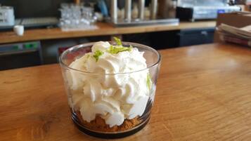 Ein Dessert in einer klaren Glasschale auf einem Holztisch.