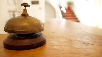 Una campana de bronce sobre una mesa de madera en el vestíbulo de un hotel.