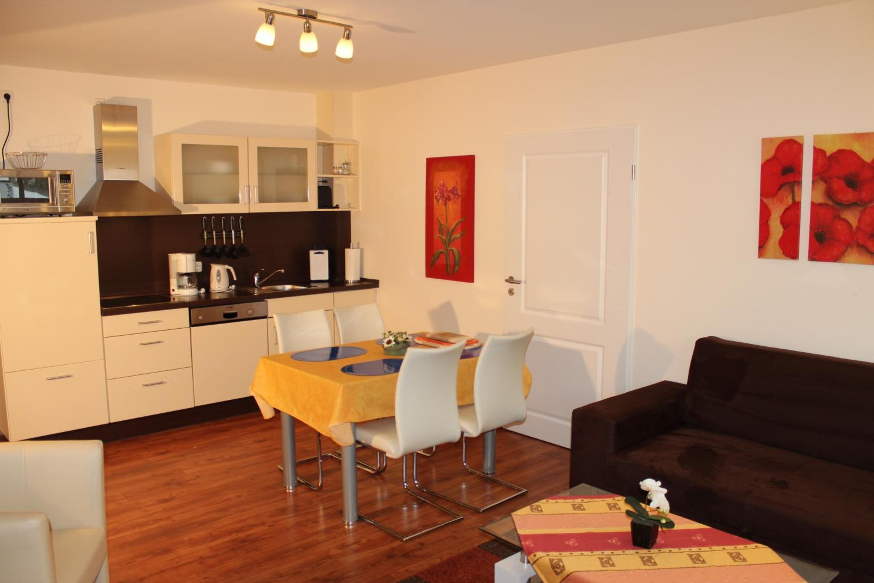 Un espacio habitable pequeño con comedor, kitchenette y sofá.