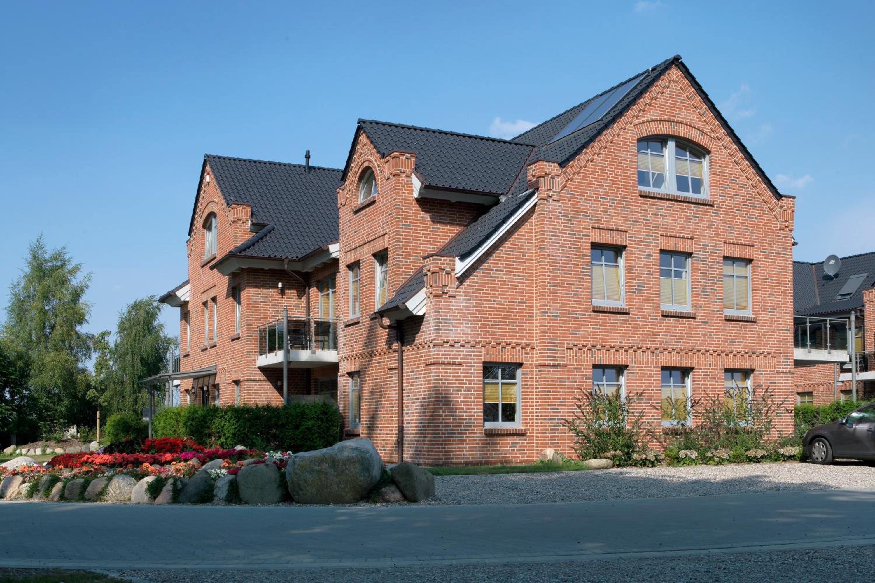 A brick building with multiple windows and a sloped roof.