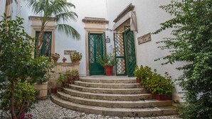 A courtyard with a set of stone steps leading to a door with a green gate. - Villa De Pietro (Cursi)