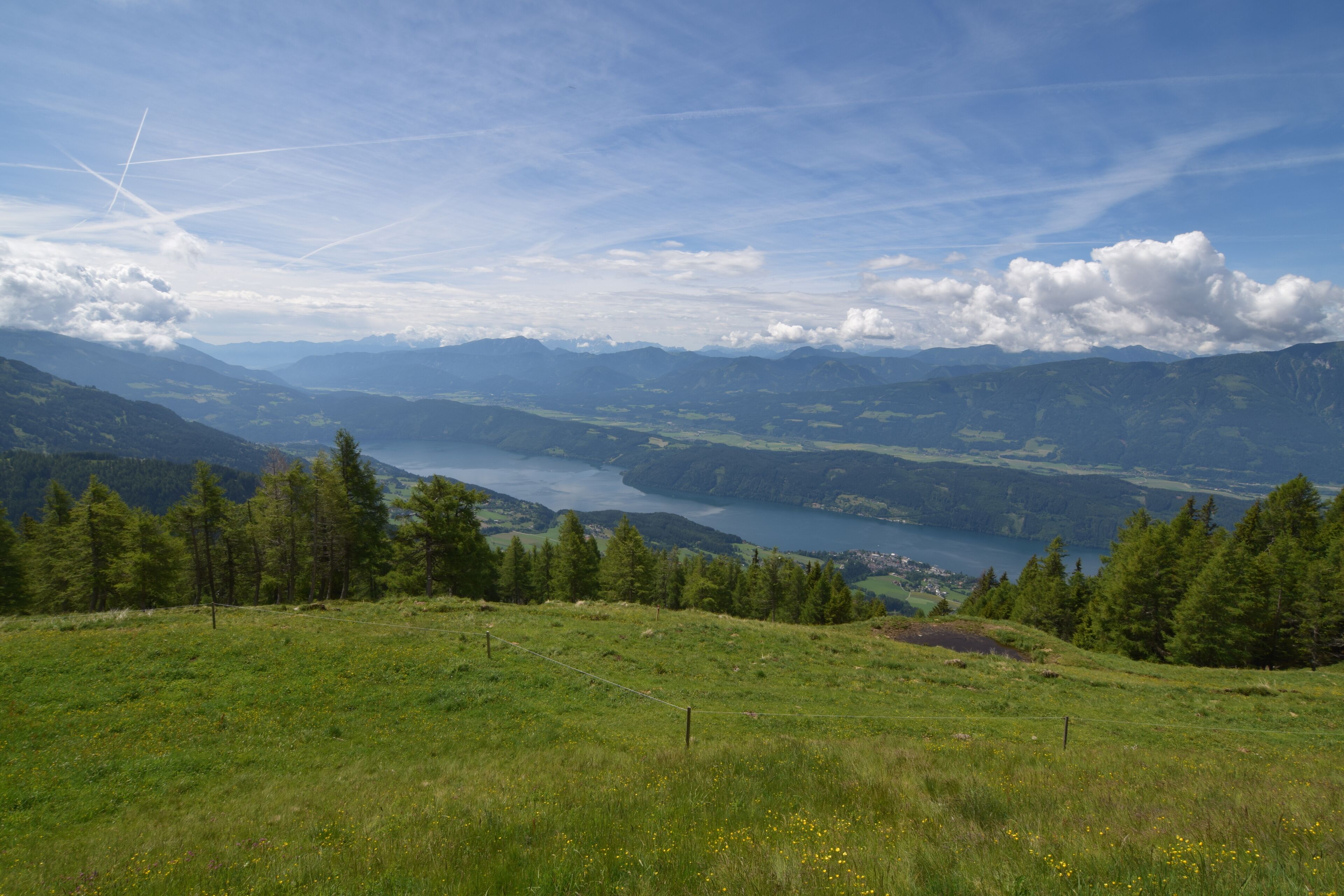 Vista panoràmica d'un paisatge montanyós amb un llac i un petit assentament a la vall.