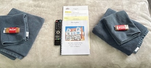 A remote control, a booklet, and two Biscuits chocolate bars on a textured surface. - Ivydene Guest House (Skegness)