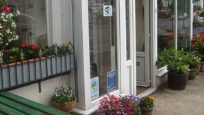 A storefront with a sign indicating a membership scheme, a Wi-Fi hotspot, and a no smoking policy. - Ivydene Guest House (Skegness)