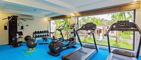 A gym with treadmills, elliptical machines, and free weights.