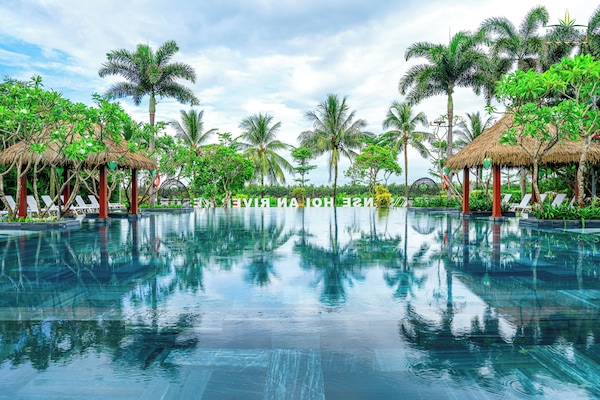 Alberca al aire libre, sombrillas en la alberca y camastros