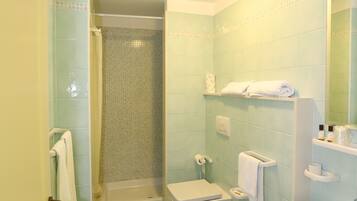 Ein Badezimmer mit Dusche, zwei Waschbecken, Toilette und Spiegel.