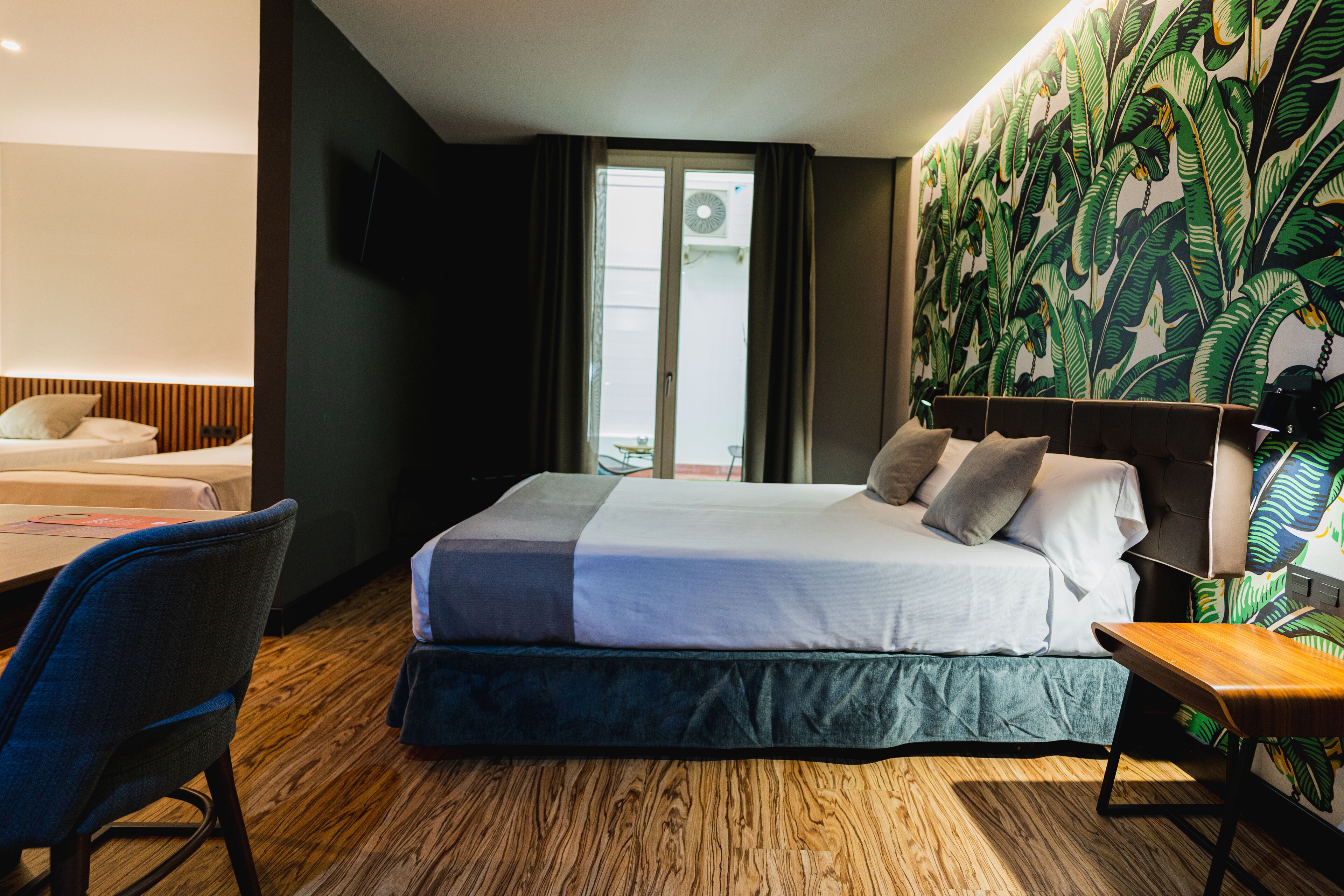 A hotel room with a bed, a desk, and a chair.