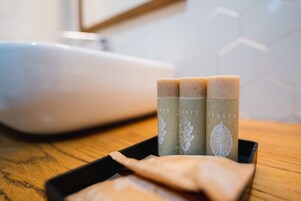 Three soap bars with leaf designs on a tray.