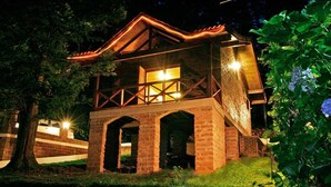 A two-story building with a balcony, brick walls, and a wooden roof. - Chalets do Vale (Gramado)