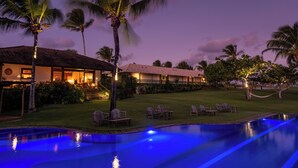A resort with a swimming pool, palm trees, and a building with a thatched roof. - Pousada Outeiro (Porto Seguro)