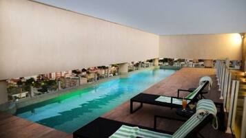 Una piscina al aire libre, tumbonas