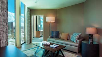 Une chambre d’hôtel moderne dotée d’une grande fenêtre, d’un canapé, d’une table basse et de deux lampadaires.