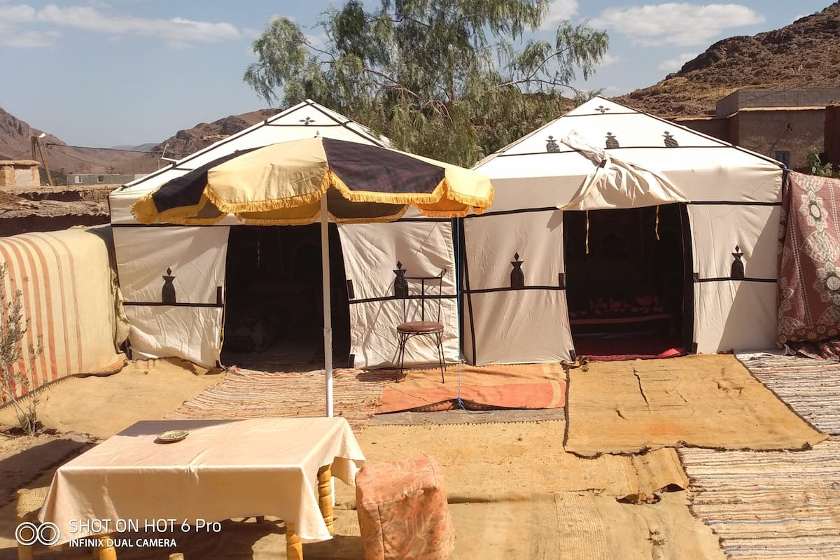 Ein Wüstencamp mit Zelten und einem Tisch.