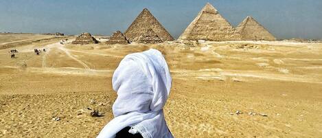 A desert landscape with pyramids in the background.