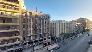 A multi-story building with balconies and a street in front. - Sufi House (Cairo)