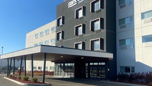 A modern building with a 'Park Inn by Radisson' sign, featuring a covered entrance and multiple windows. - Park Inn by Radisson Edmonton Airport (Leduc)