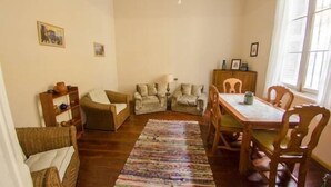 Una sala de estar acogedora con una mesa de comedor de madera, dos sofás y una alfombra.