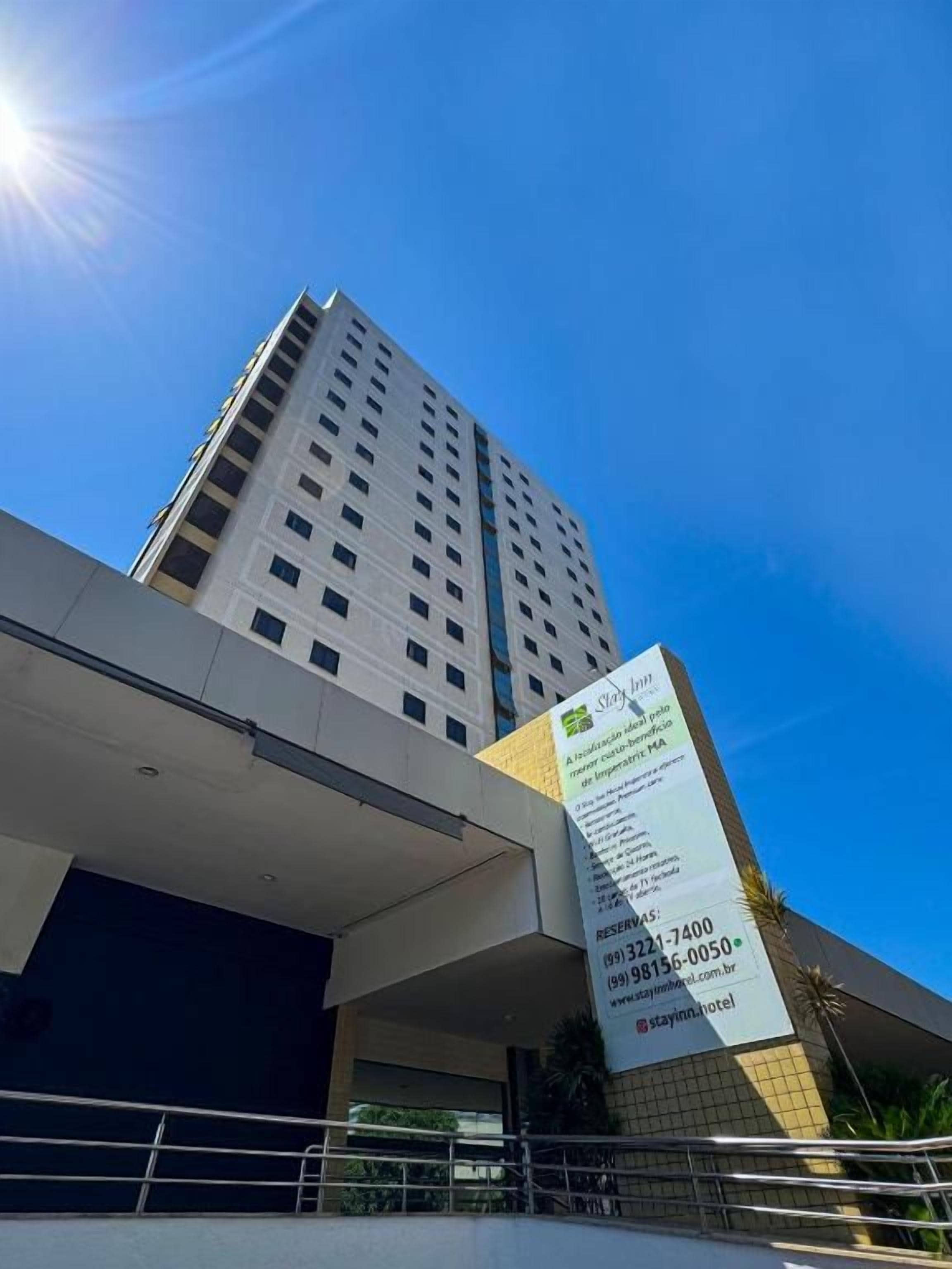 Un edificio alto con un cartel que anuncia un hotel.