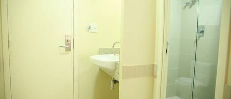 A bathroom with a sink, a toilet, and a glass shower enclosure.