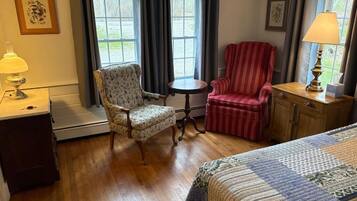 Una habitación con cama, una silla, una mesa y una lámpara.