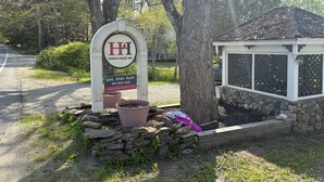 A sign for Hawks House Inn with a contact number and website. - Hawks House Inn (Walpole)
