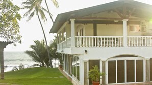 A two-story house with a balcony, a view of the ocean, and a well-maintained lawn. - Quinta MonteCarlo (La Libertad)