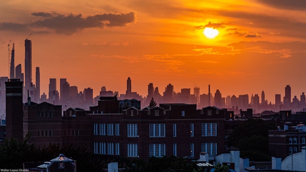 Un horizonte urbano al atardecer con edificios destacados y un cielo despejado.