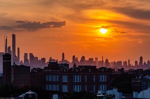 Une vue sur les gratte-ciel d’une ville au coucher du soleil, avec des bâtiments imposants et un ciel dégagé.