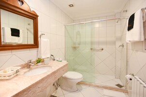 Un bagno moderno con un lavabo in marmo, un box doccia in vetro e un water.