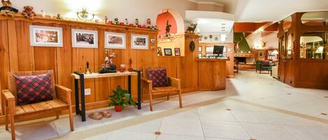 A cozy lobby with wooden paneling, a reception desk, and seating areas.